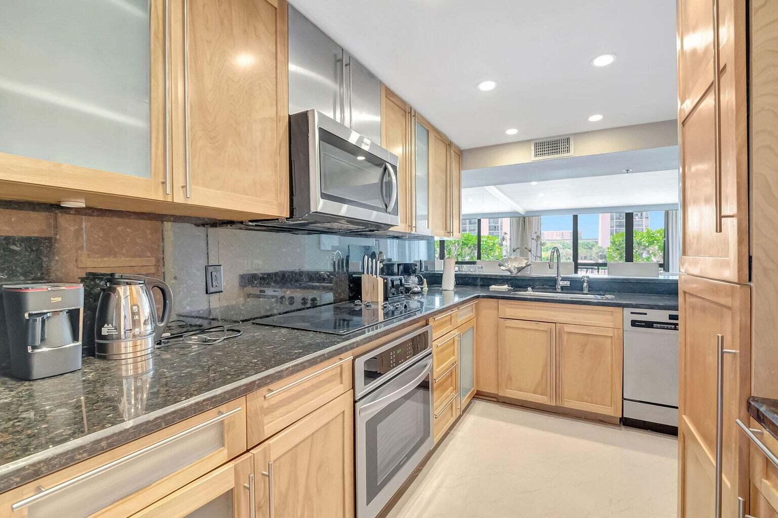 2707 North Ocean Boulevard, Unit D205 Boca Raton, FL 33431 - Photo 20 of 51 a kitchen with stainless steel appliances granite countertop a sink and cabinets