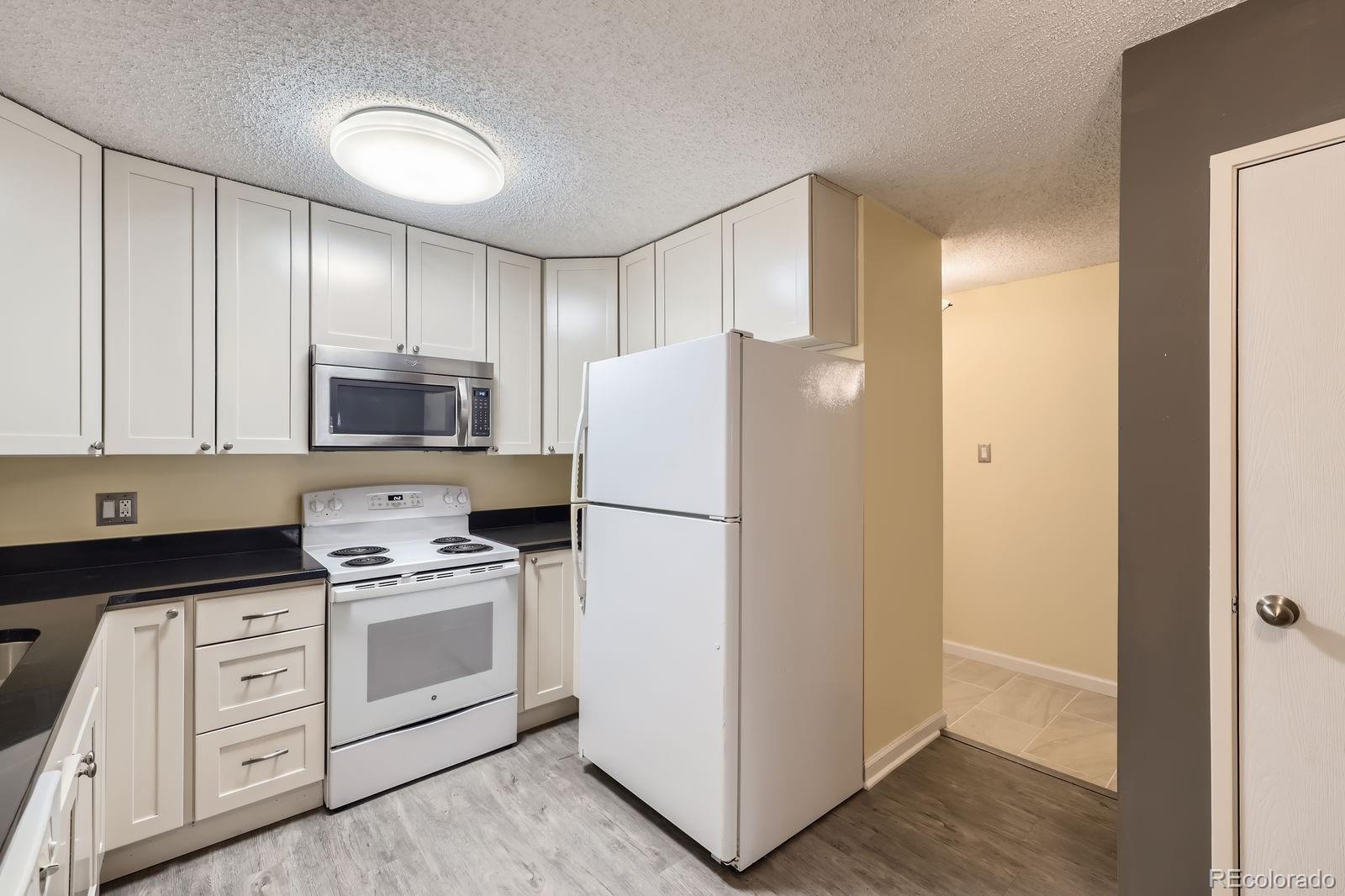 3124 South Wheeling Way, Unit 102 Aurora, CO 80014 - Photo 11 of 17 a white refrigerator freezer sitting in a kitchen