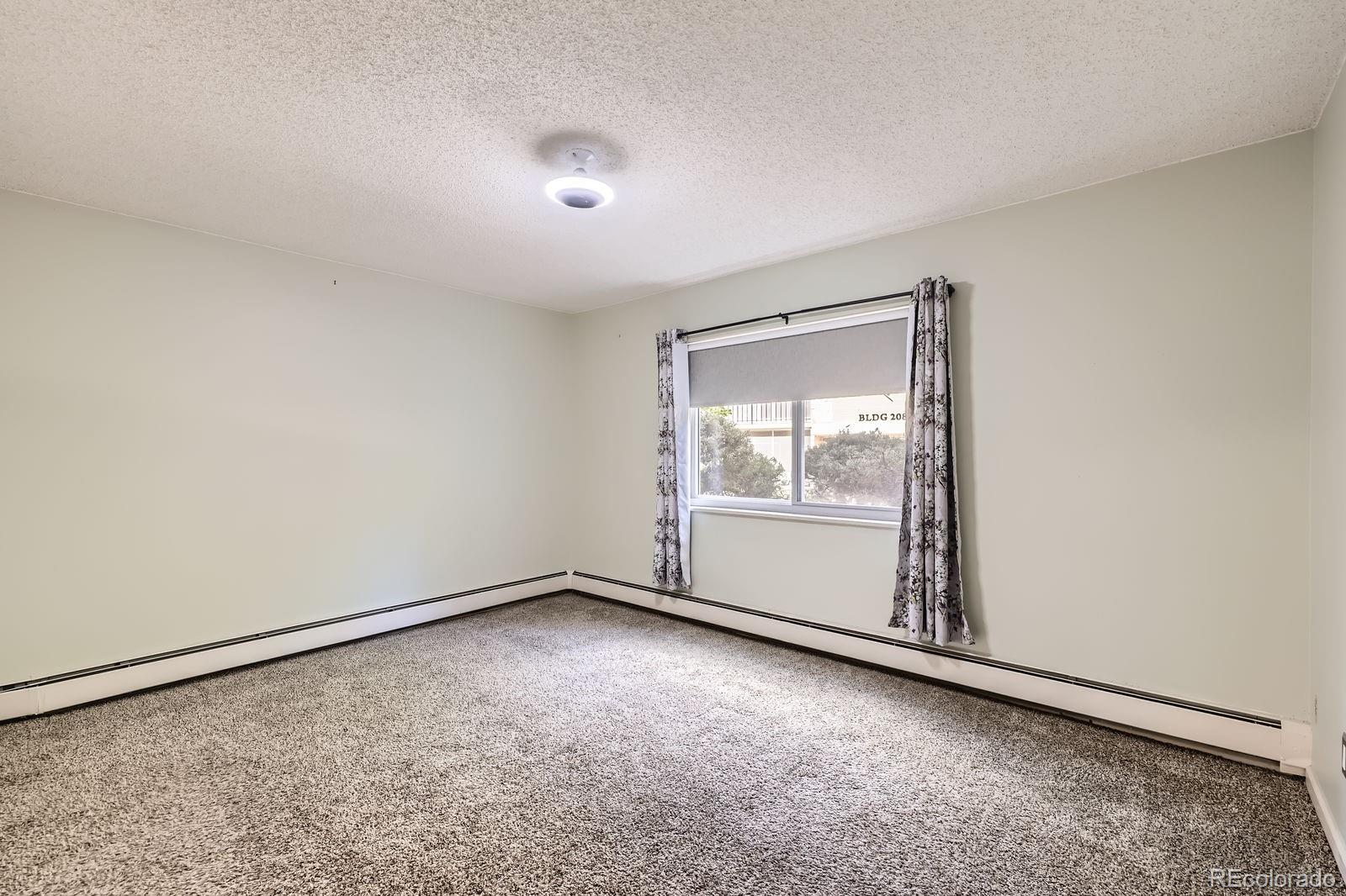 3124 South Wheeling Way, Unit 102 Aurora, CO 80014 - Photo 12 of 17 an empty room with a empty space and window