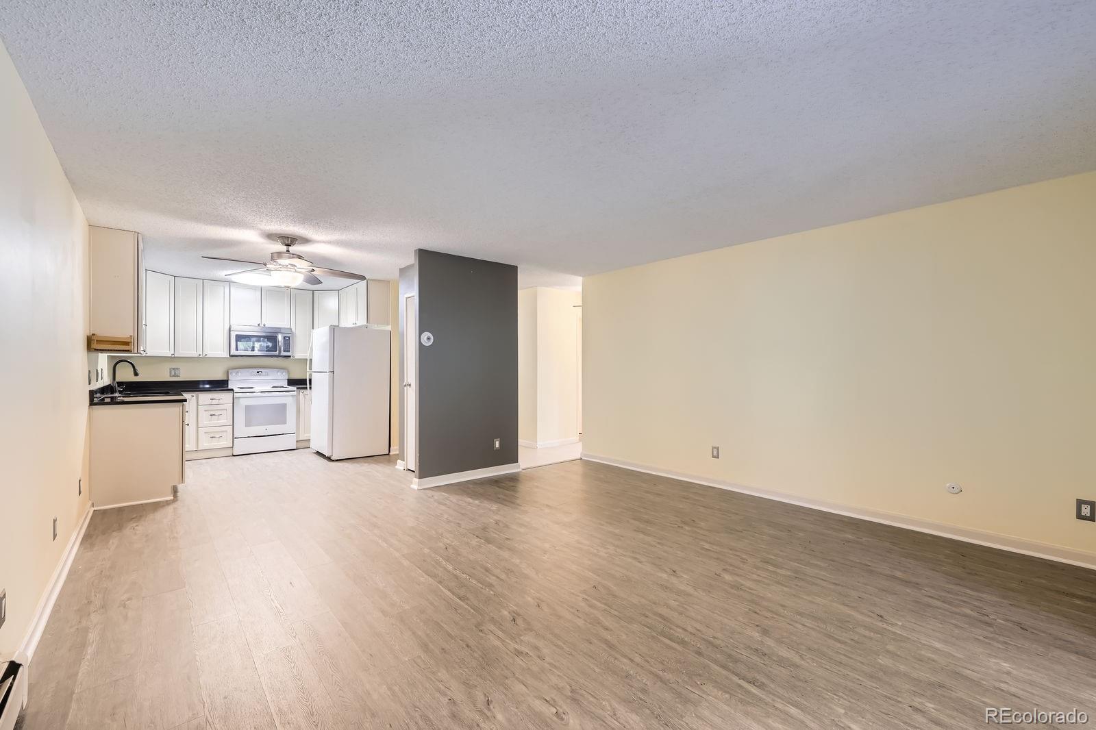 3124 South Wheeling Way, Unit 102 Aurora, CO 80014 - Photo 8 of 17 a view of kitchen with refrigerator and wooden floor