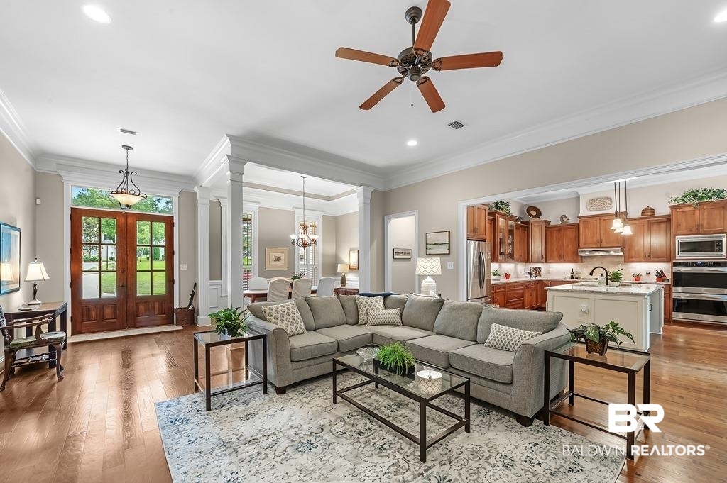30014 Dolive Ridge Daphne, AL 36527 - Photo 10 of 57 Living room featuring light hardwood / wood-style flooring, ceiling fan with notable chandelier, and crown molding