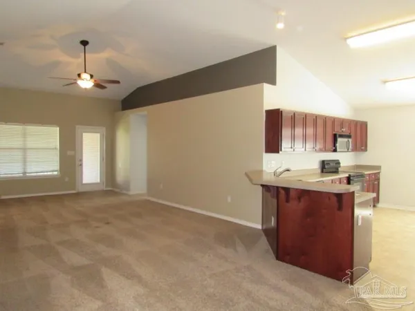 an empty room with windows and fan