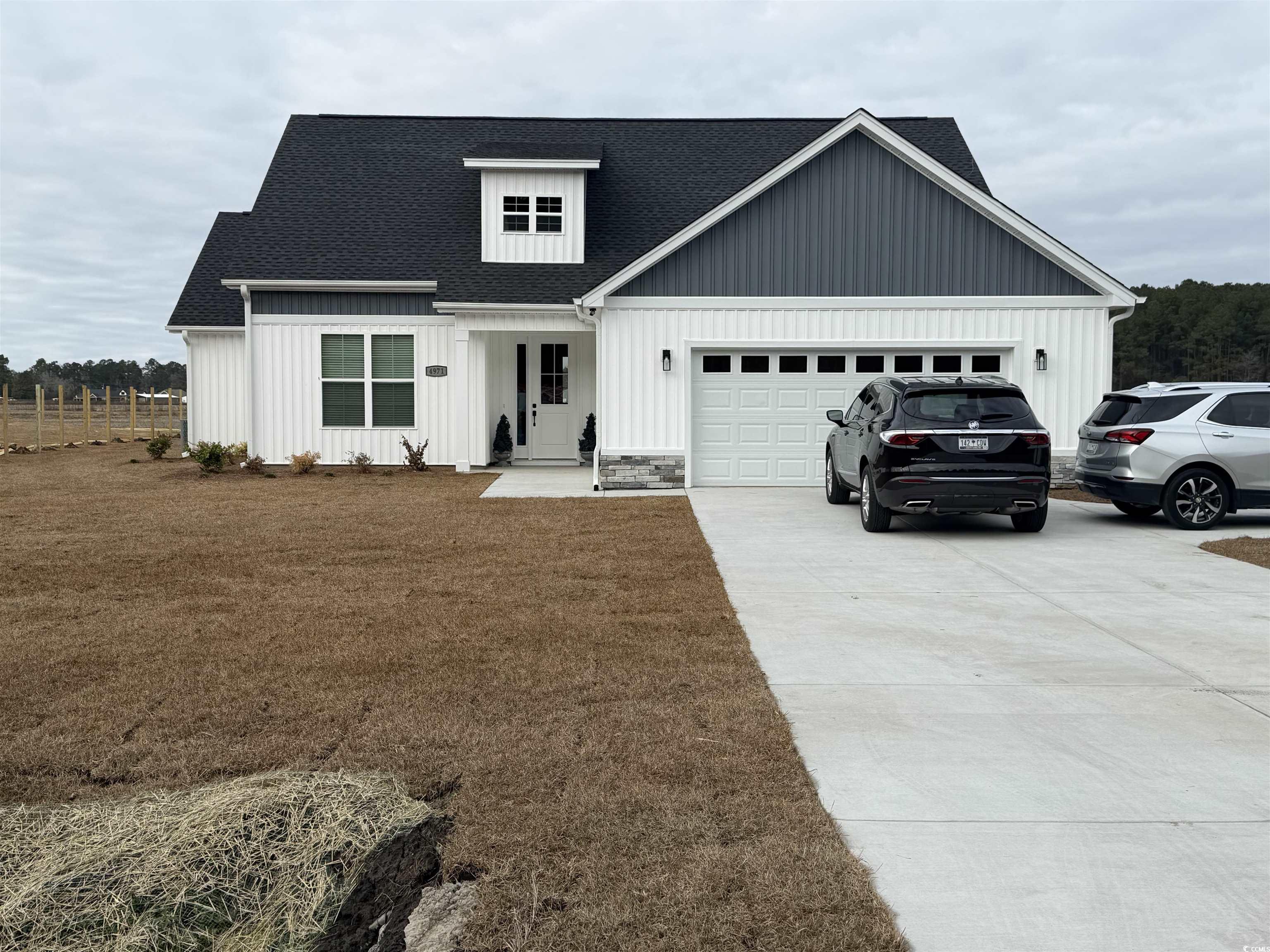 Modern inspired farmhouse featuring roof with shingles, driveway, a garage, and a porch