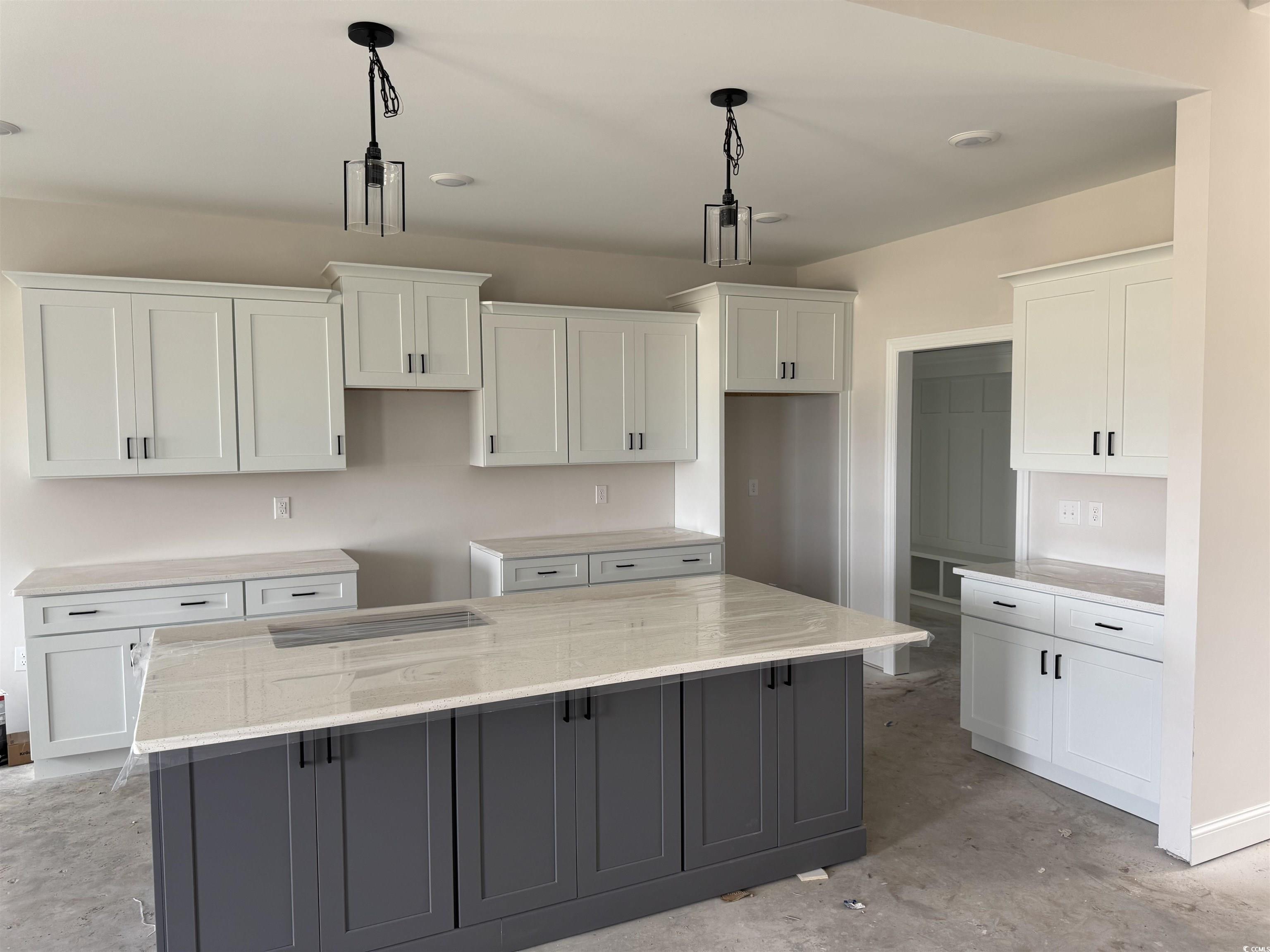 4971 Dupont Road Aynor, SC 29511 - Photo 3 of 12 Kitchen with white cabinets, concrete flooring, a kitchen island, decorative light fixtures, and light stone counters