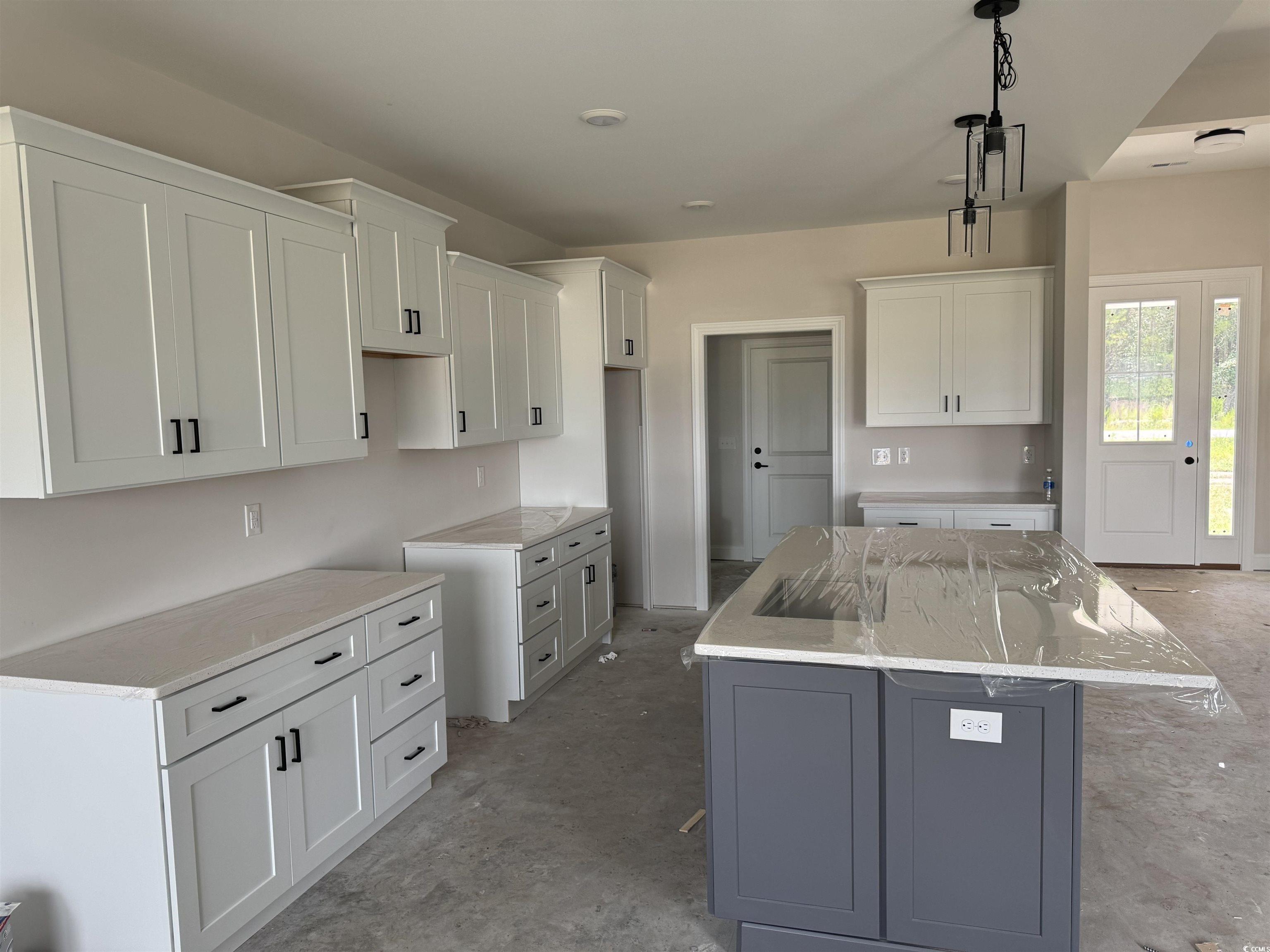 4971 Dupont Road Aynor, SC 29511 - Photo 4 of 12 Kitchen featuring a kitchen island with sink, white cabinets, light stone countertops, and decorative light fixtures