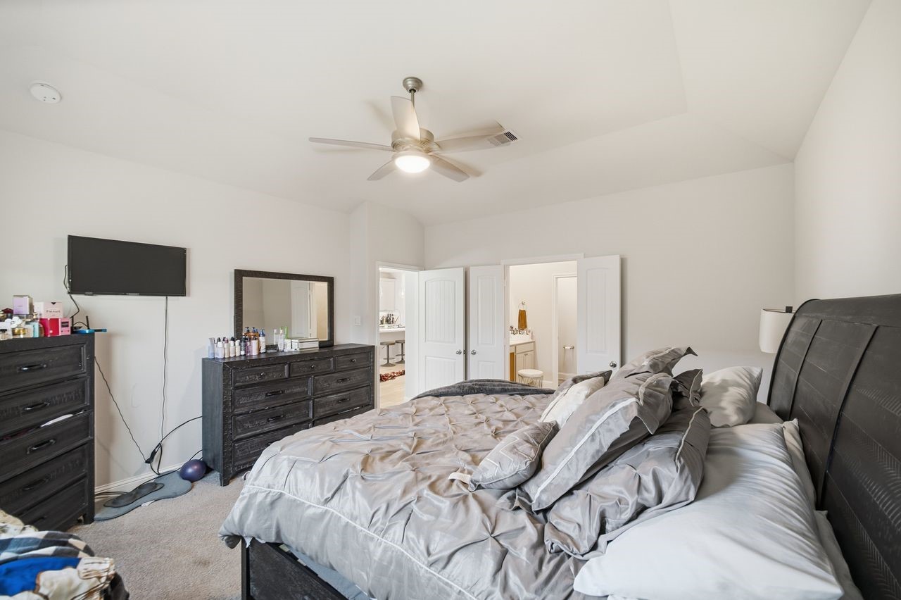 15326 Leal Rancho Court Cypress, TX 77433 - Photo 20 of 31 a bedroom with a bed and a flat screen tv