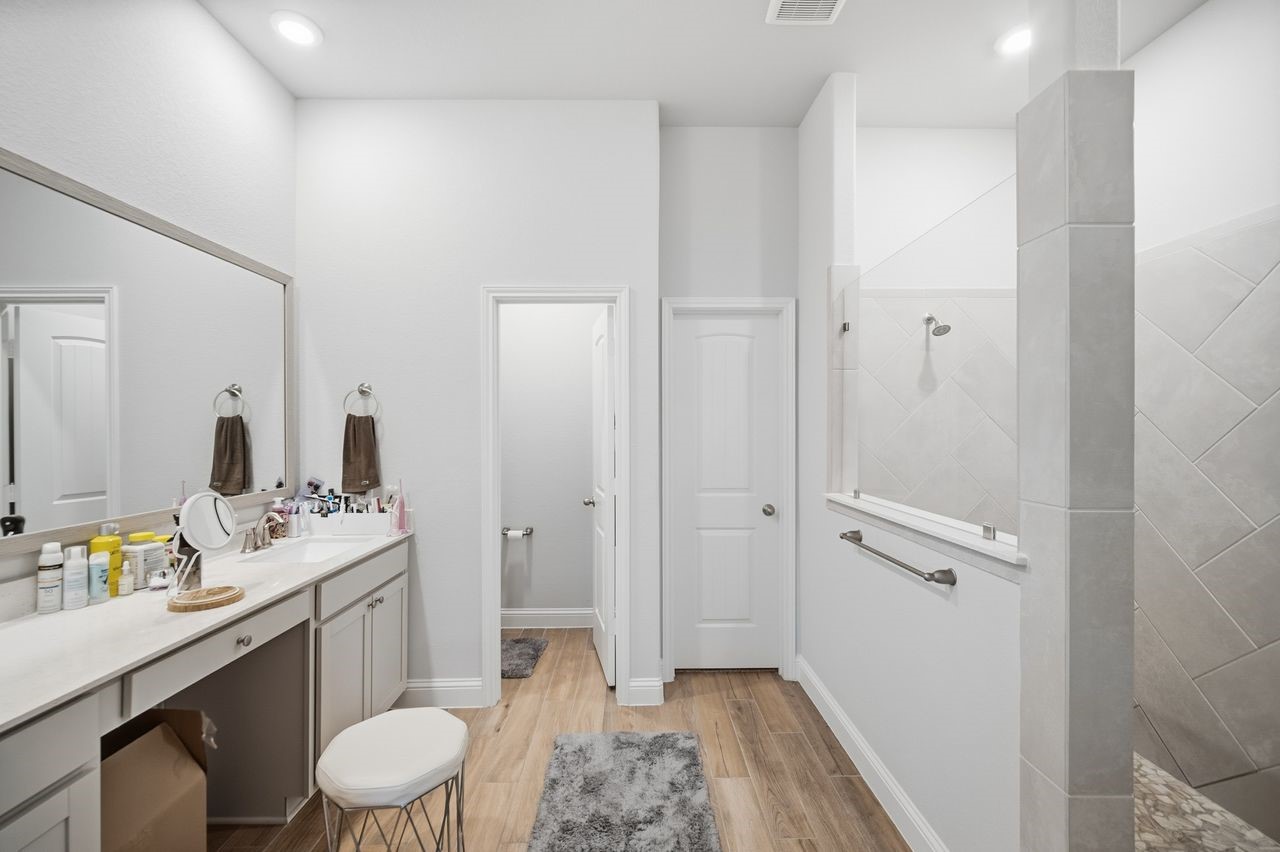 15326 Leal Rancho Court Cypress, TX 77433 - Photo 21 of 31 a bathroom with a sink a toilet a mirror and vanity
