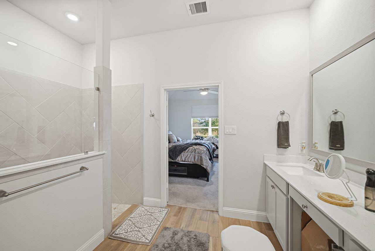 15326 Leal Rancho Court Cypress, TX 77433 - Photo 22 of 31 a en suite bathroom with a granite countertop sink and a mirror