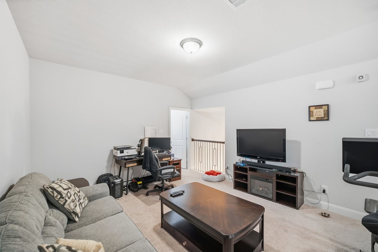 15326 Leal Rancho Court Cypress, TX 77433 - Photo 27 of 31 a living room with furniture and a flat screen tv