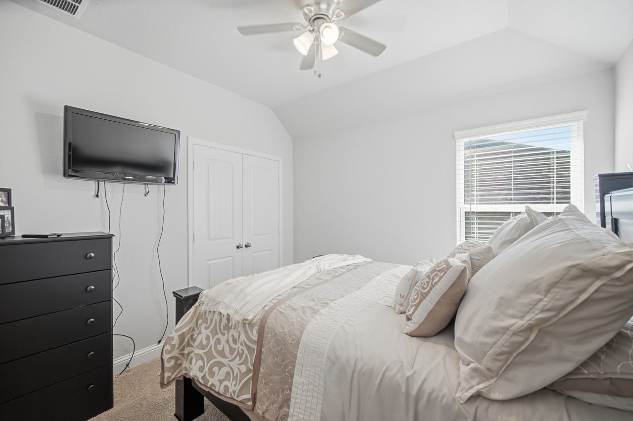 15326 Leal Rancho Court Cypress, TX 77433 - Photo 28 of 31 a bedroom with a bed and a flat screen tv