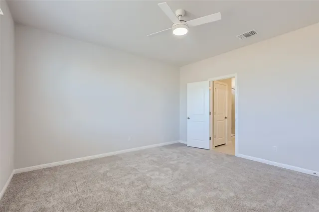 an empty room with a ceiling fan and a window