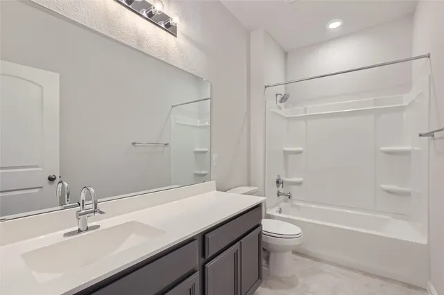 a bathroom with a granite countertop sink a toilet and shower