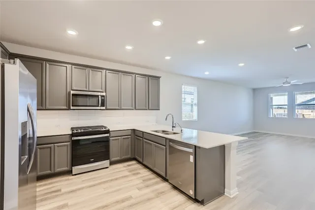 a kitchen with stainless steel appliances granite countertop a sink stove and microwave