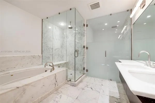 a spacious bathroom with a tub sink shower and a mirror