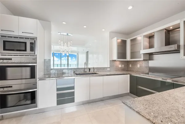 a kitchen with granite countertop a sink and stainless steel appliances