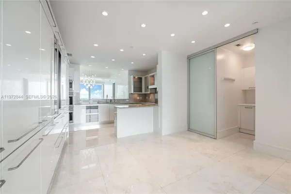 a view of kitchen with kitchen island white cabinets and refrigerator