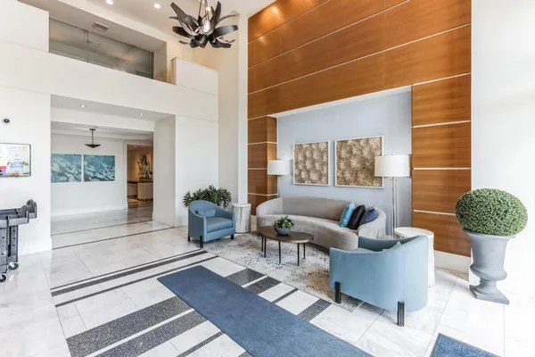 a living room with furniture a chandelier and a rug
