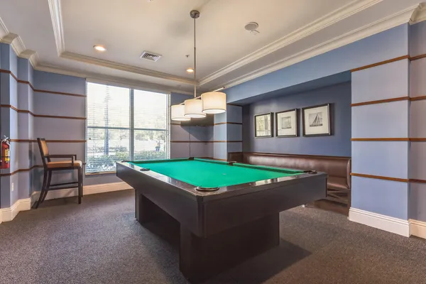 a room with pool table and windows