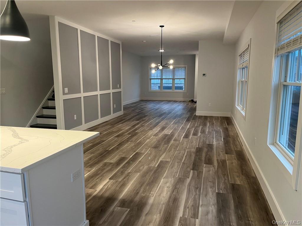 195 Park Avenue, Unit C West Harrison, NY 10604 - Photo 10 of 32 Unfurnished dining area with a chandelier, dark wood-type flooring, and stairs