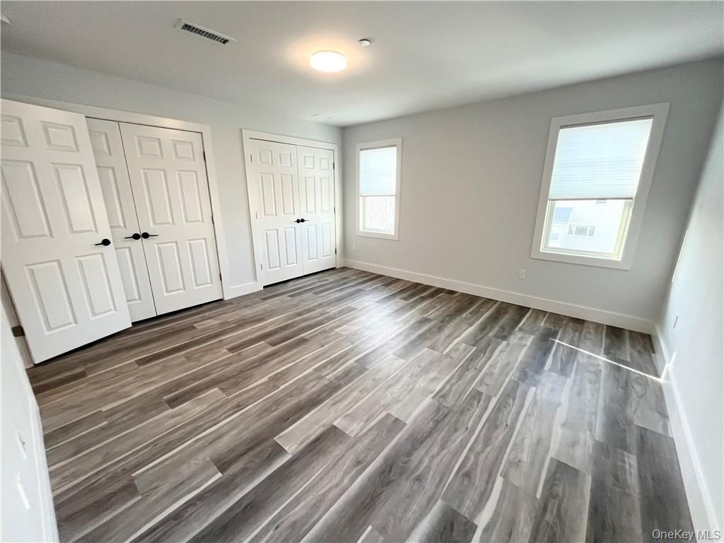 195 Park Avenue, Unit C West Harrison, NY 10604 - Photo 15 of 32 Unfurnished bedroom featuring two closets and dark wood finished floors