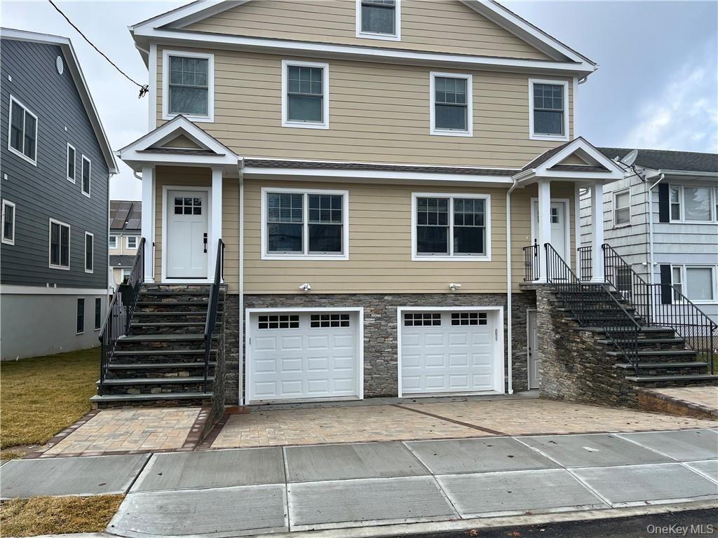 195 Park Avenue, Unit C West Harrison, NY 10604 - Photo 29 of 32 View of front of property featuring driveway, an attached garage, and stone siding