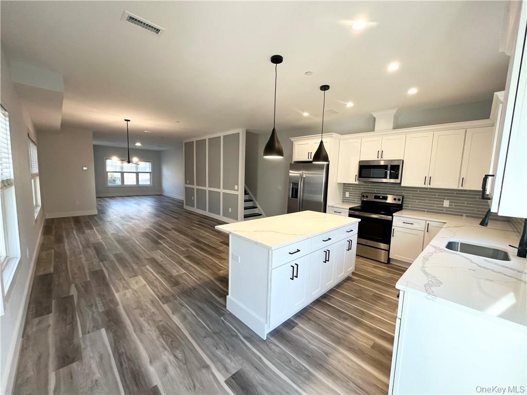 195 Park Avenue, Unit C West Harrison, NY 10604 - Photo 30 of 32 Kitchen with stainless steel appliances, pendant lighting, a center island, backsplash, and open floor plan