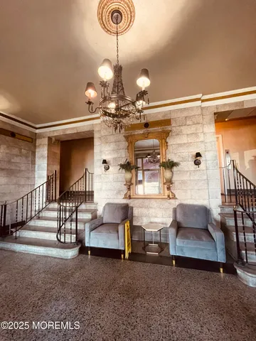 a living room with couches and dining table with a chandelier