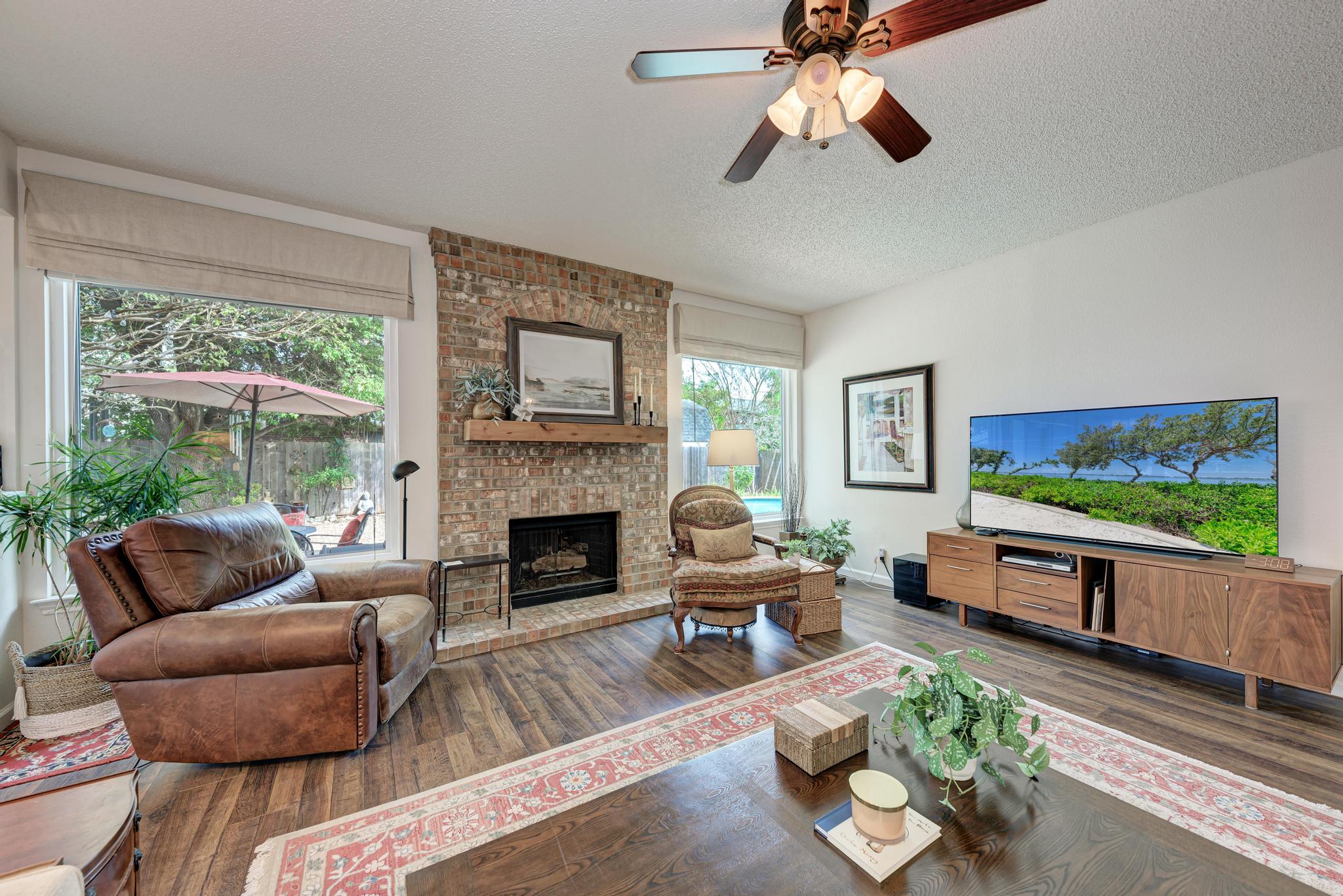 404 Cripple Creek Road Cedar Park, TX 78613 - Photo 12 of 39 a living room with furniture a flat screen tv and a fireplace