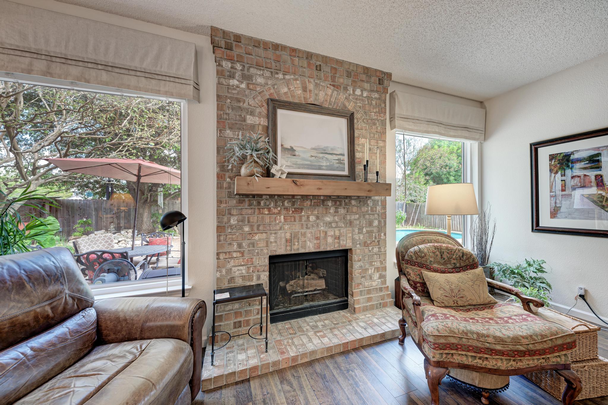 404 Cripple Creek Road Cedar Park, TX 78613 - Photo 13 of 39 Living room with hardwood / wood-style floors, a fireplace, and a textured ceiling