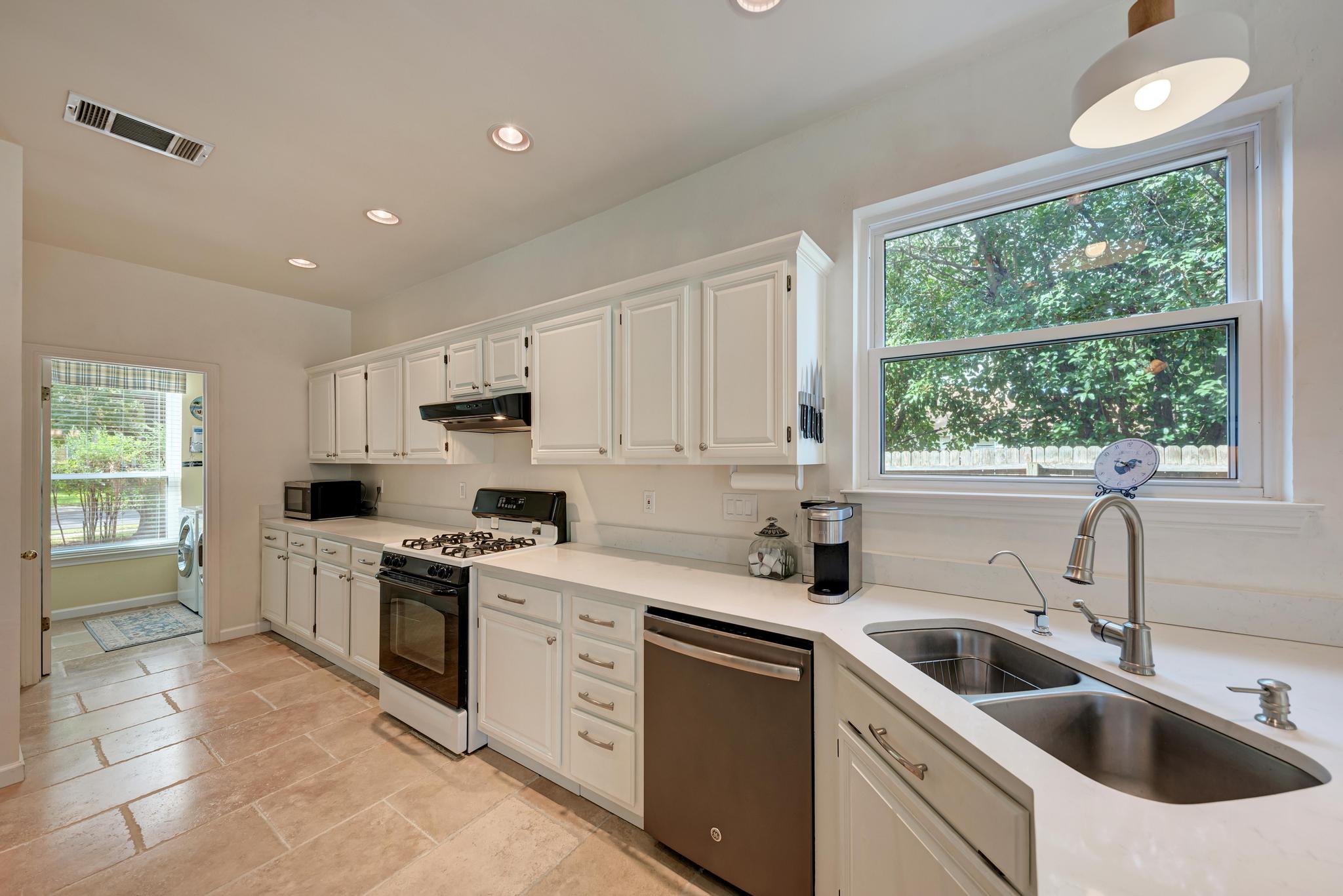 404 Cripple Creek Road Cedar Park, TX 78613 - Photo 17 of 39 a kitchen with a sink white cabinets and white appliances