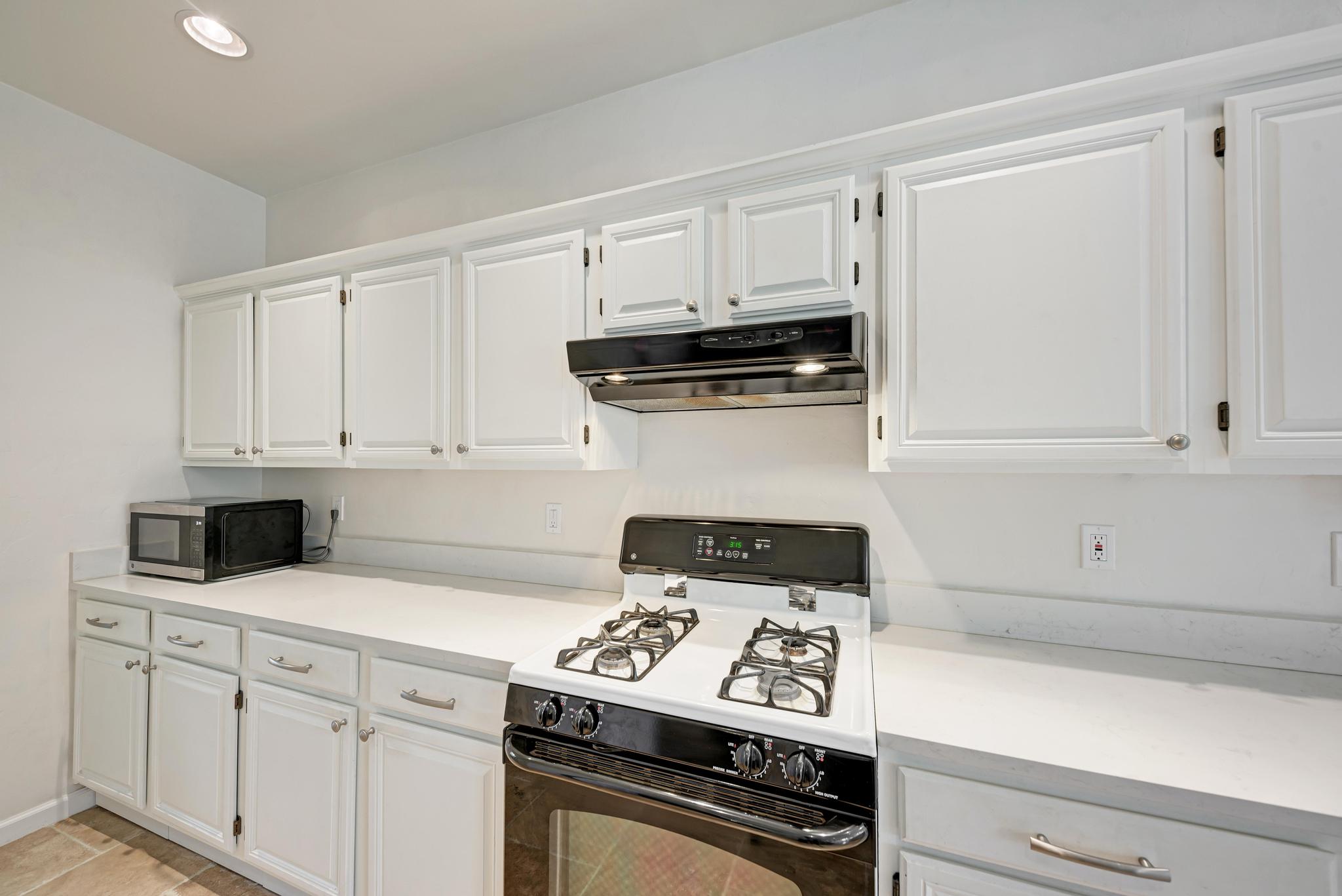 404 Cripple Creek Road Cedar Park, TX 78613 - Photo 19 of 39 a kitchen with white cabinets and black appliances