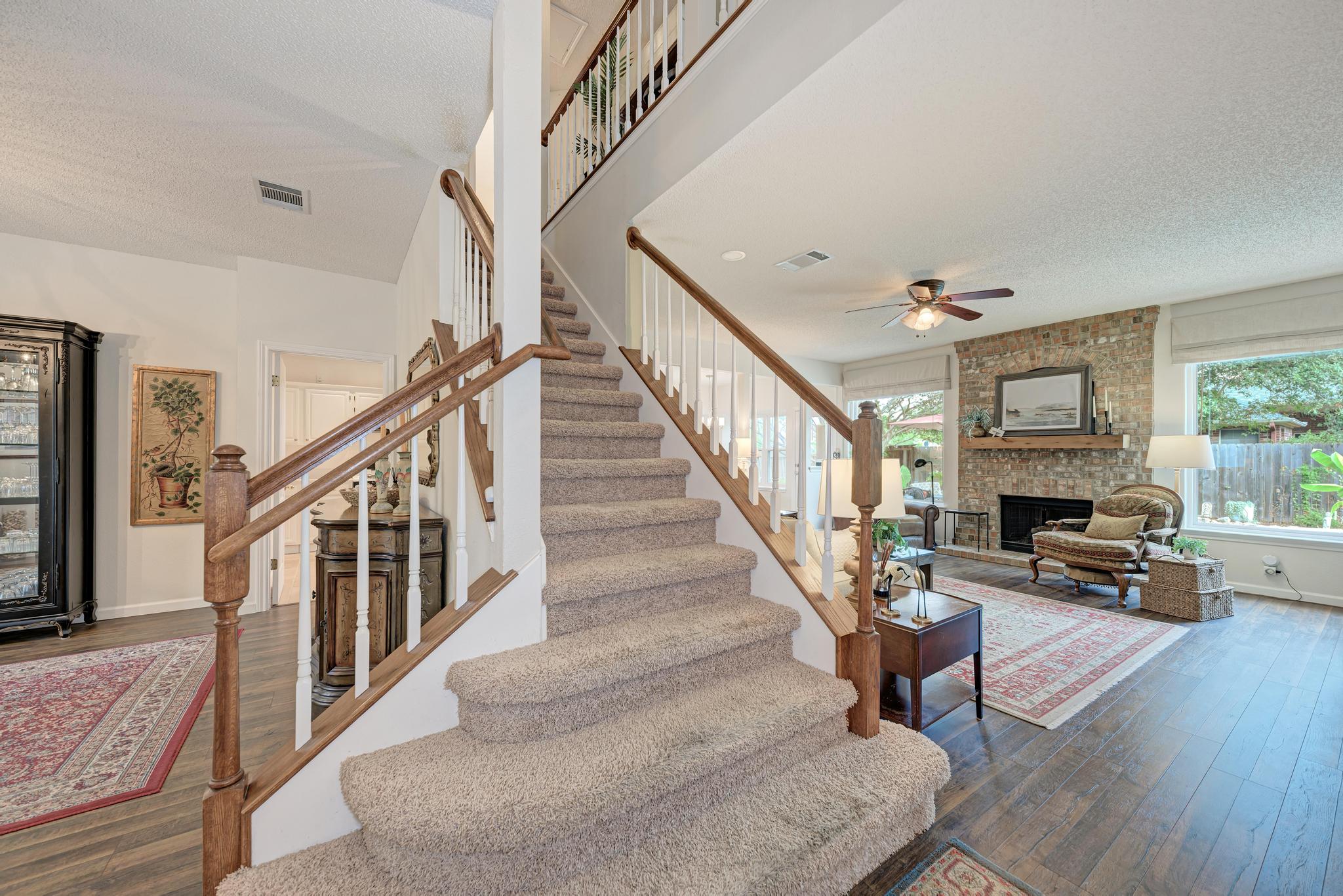 404 Cripple Creek Road Cedar Park, TX 78613 - Photo 27 of 39 Stairs featuring a hardwood / wood-style floors, a fireplace, and ceiling fan