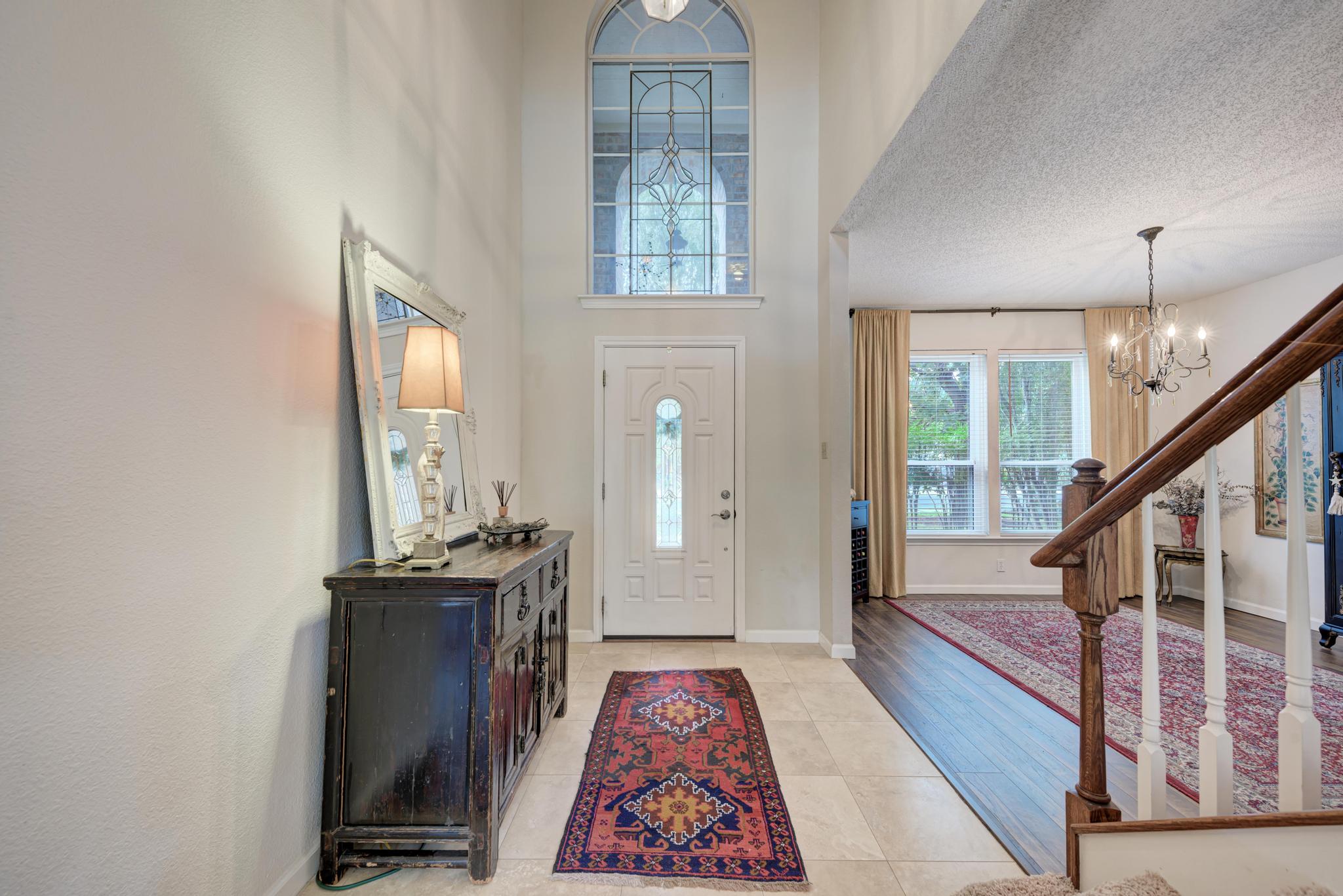 404 Cripple Creek Road Cedar Park, TX 78613 - Photo 8 of 39 Entrance foyer featuring a textured ceiling, a high ceiling, a chandelier, and light tile patterned flooring