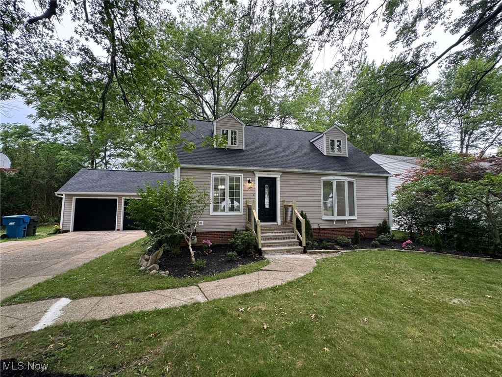 4018 Root Road North Olmsted, OH 44070 - Photo 2 of 23 Cape cod house with driveway, a front lawn, a garage, and roof with shingles