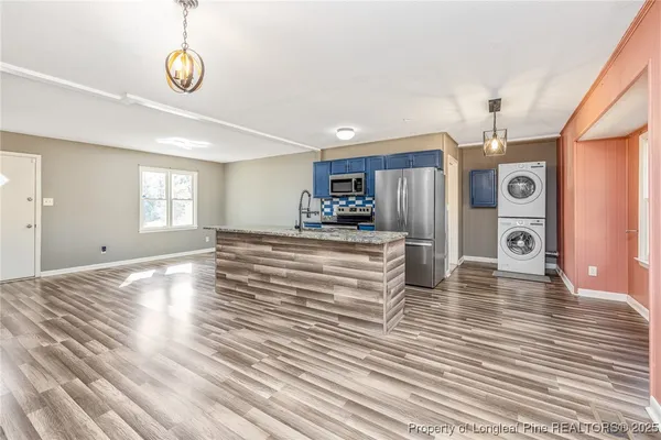 a kitchen with stainless steel appliances granite countertop a refrigerator a stove top oven a sink and dishwasher
