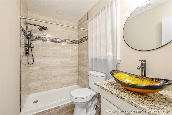 a bathroom with a granite countertop sink and a large mirror