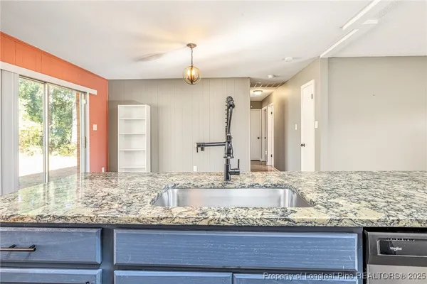 an empty room with windows and a chandelier fan
