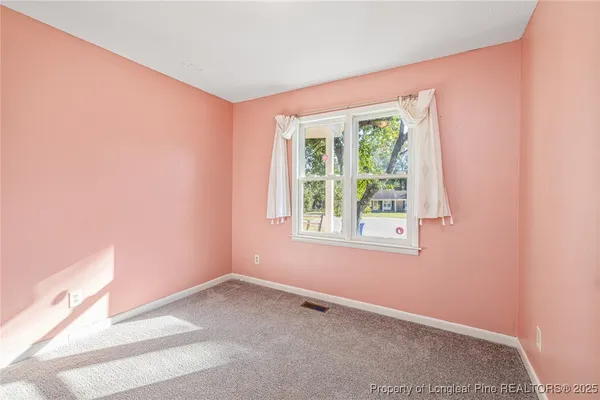 an empty room with closet and a chandelier fan