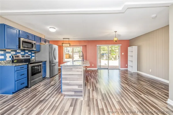 a kitchen with stainless steel appliances wooden floors and wooden cabinets