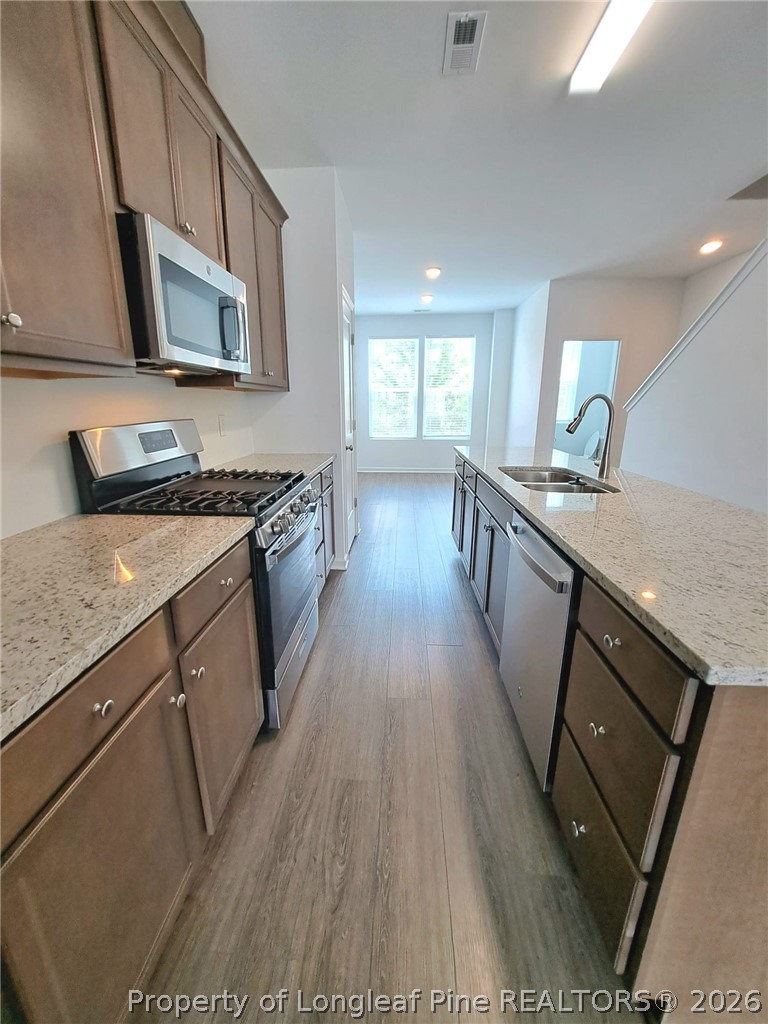 1939 Robin Hill Lane Raleigh, NC 27610 - Photo 11 of 25 a kitchen with a sink a microwave a refrigerator and cabinets