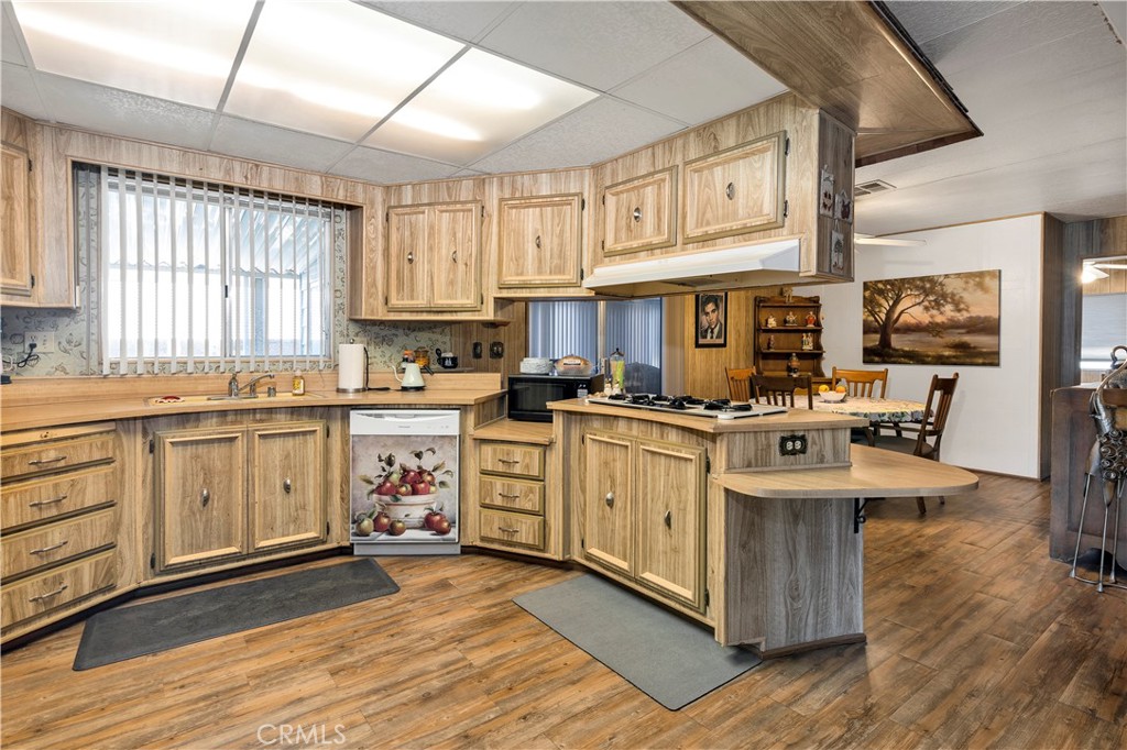 2230 Lake Park Drive, Unit 170 San Jacinto, CA 92583 - Photo 13 of 40 a kitchen with stainless steel appliances white cabinets and wooden floors
