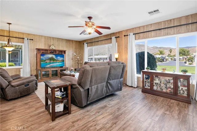 a living room with furniture and a flat screen tv with wooden floor