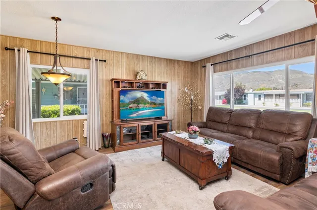 a living room with furniture a large window and a flat screen tv