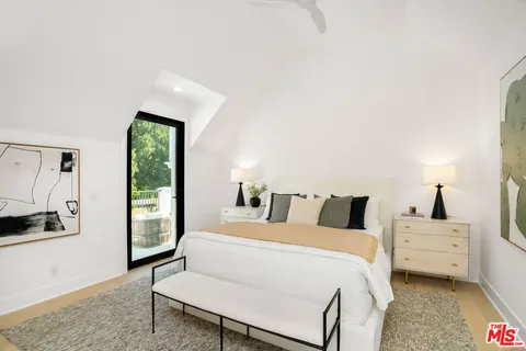 a living room with furniture a bookshelf and a large window