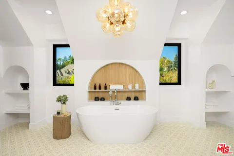 a view of a dining room and livingroom with furniture wooden floor a chandelier