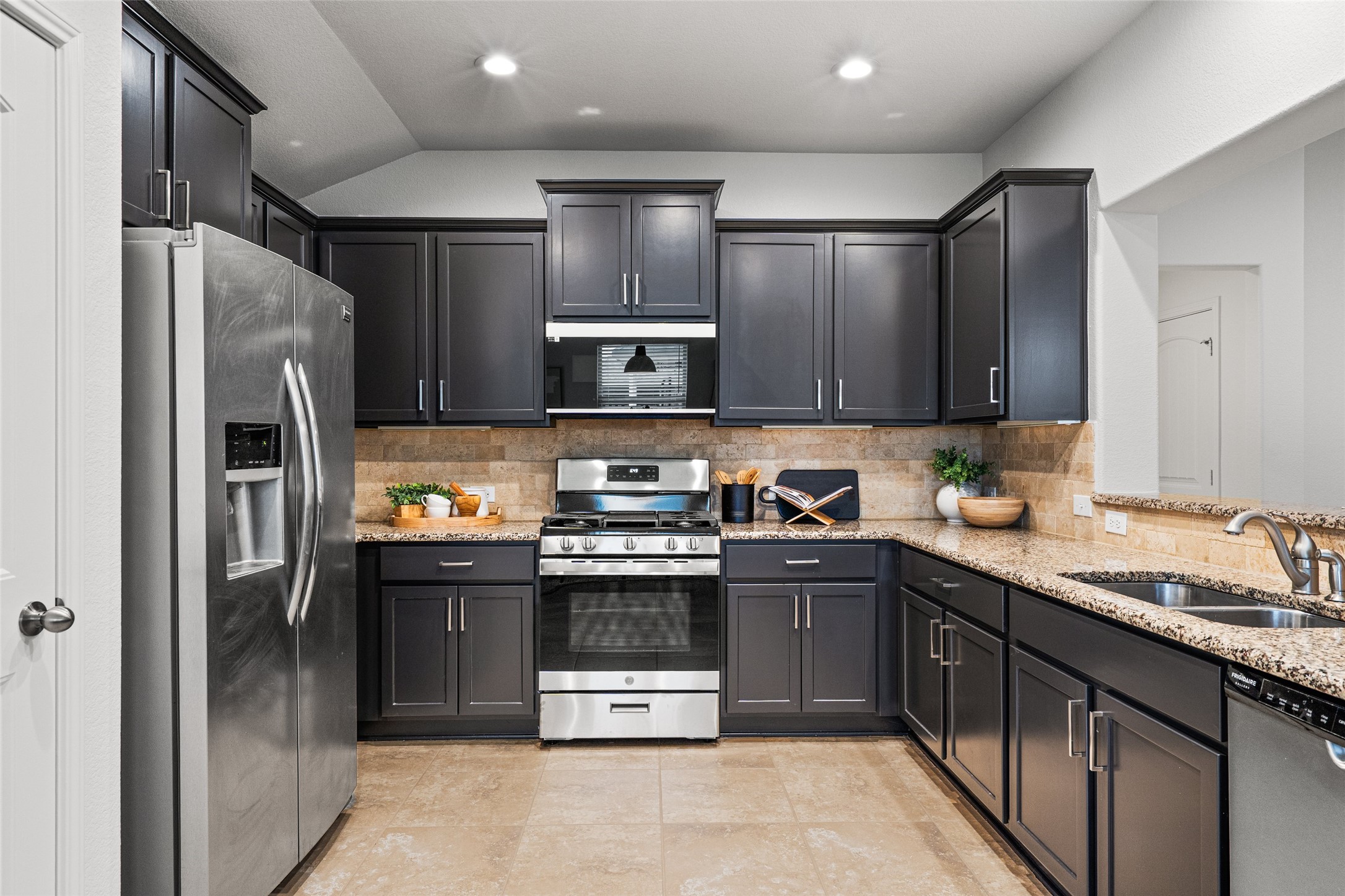 705 Schefer Street Leander, TX 78641 - Photo 12 of 26 a kitchen with stainless steel appliances granite countertop a refrigerator and a sink