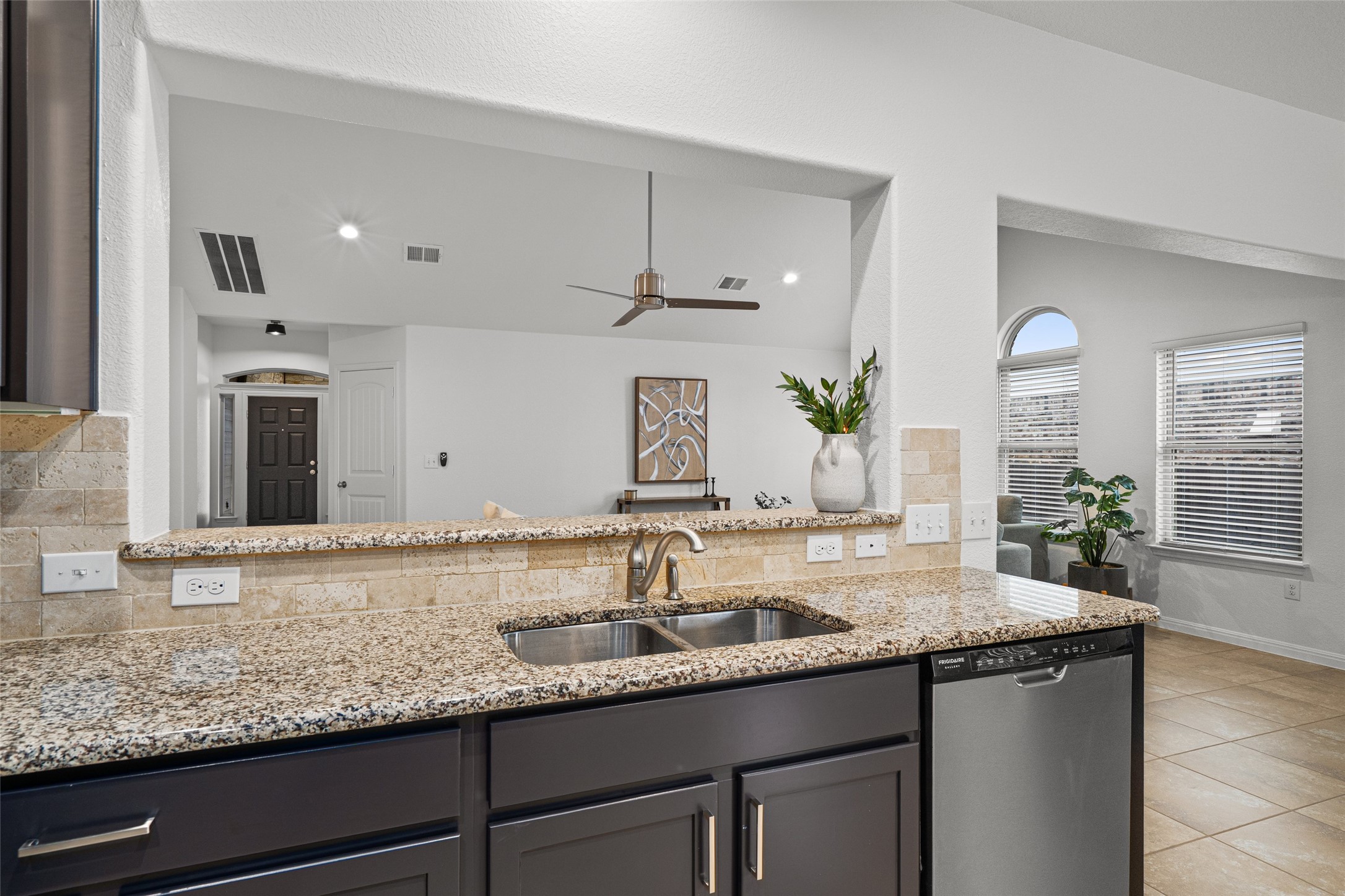 705 Schefer Street Leander, TX 78641 - Photo 13 of 26 a bathroom with a granite countertop sink a large mirror and a window
