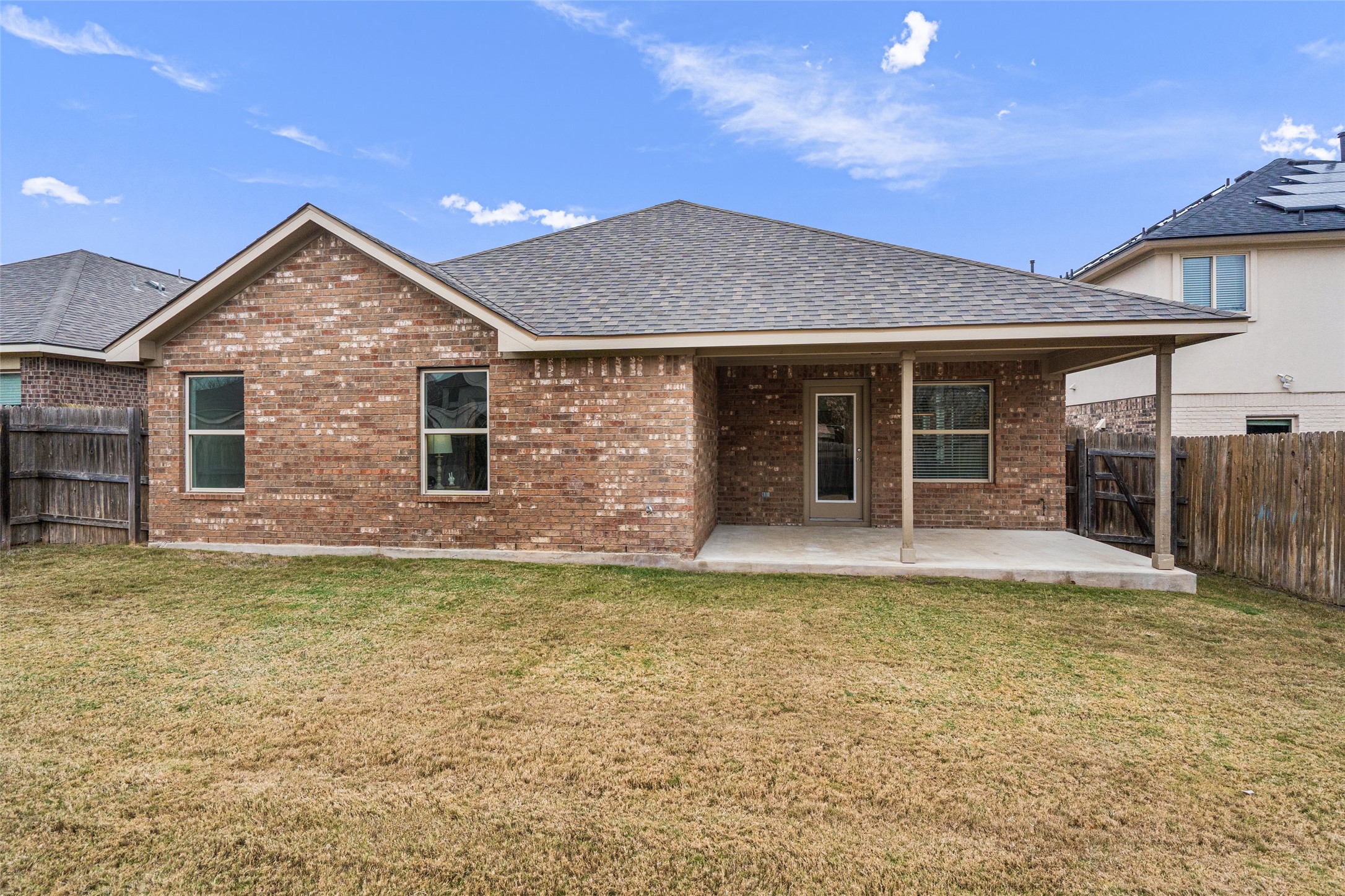 705 Schefer Street Leander, TX 78641 - Photo 25 of 26 a view of a house with floor to ceiling windows and a flat screen tv