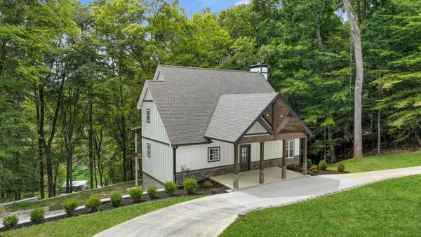 a view of a house with backyard and a tree