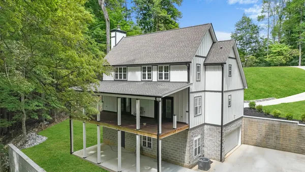 an aerial view of lake residential house with outdoor space and trees around